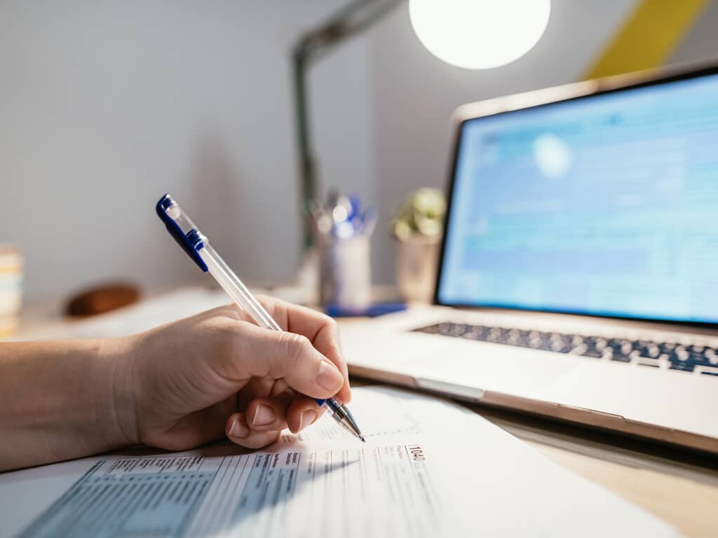 a person working on a document in front of a laptop
